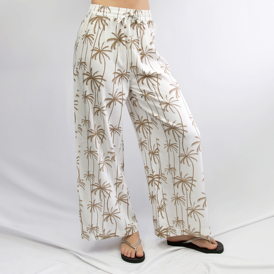 Front view of Carve Sobi Women’s Beach Pant, available at Stewart’s Menswear Mullumbimby. White and tan palm print linen-viscose relaxed fit beach pants.