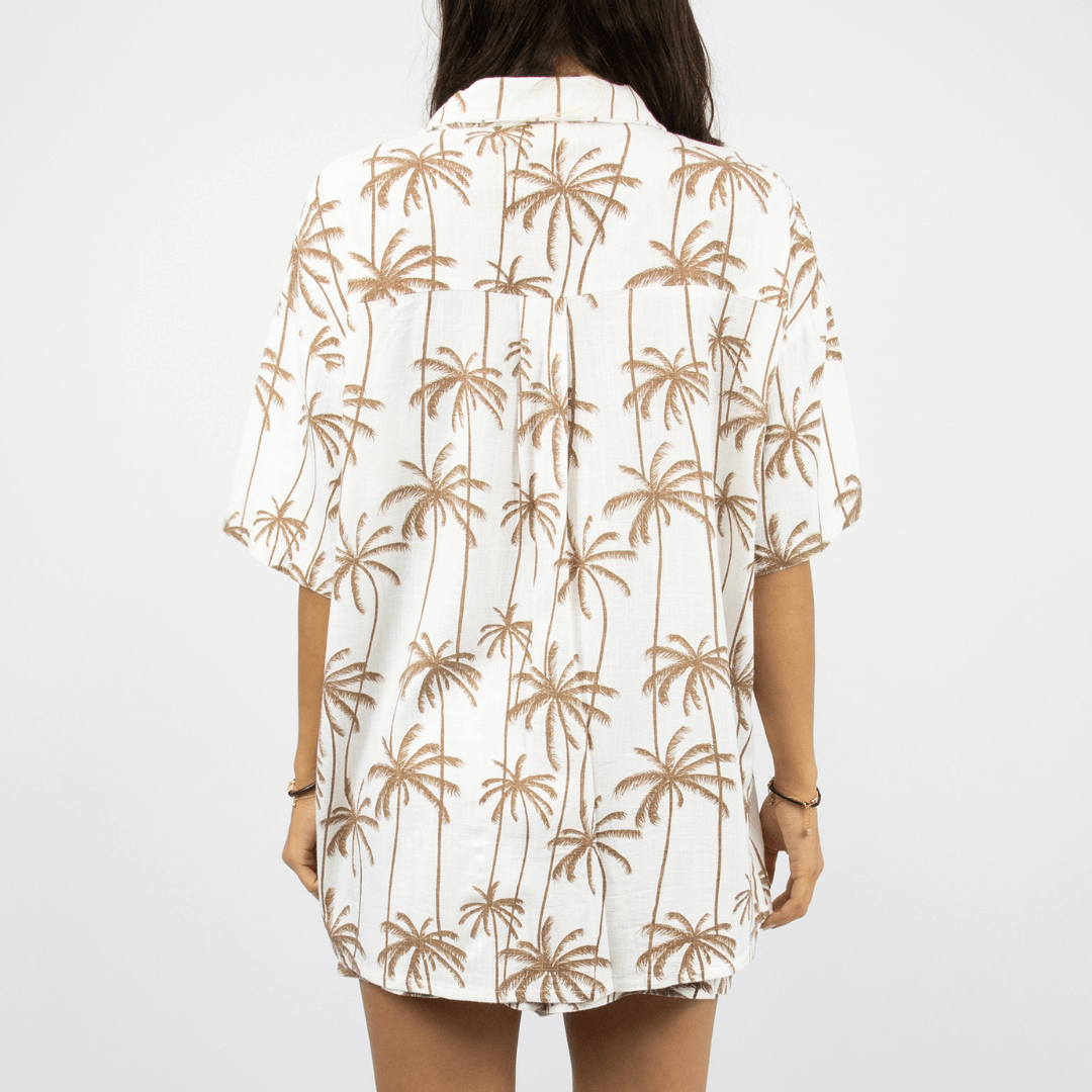 Back view of Sobi Women's Beach set available at Stewarts Menswear in Mullumbimby. White and tan palm print linen-viscose shirt and shorts set.