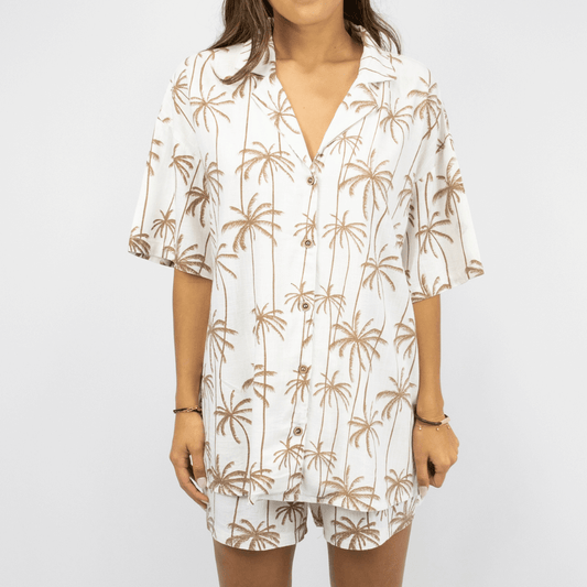 Front view of Sobi Women's Beach set available at Stewarts Menswear in Mullumbimby. White and tan palm print linen-viscose shirt and shorts set.