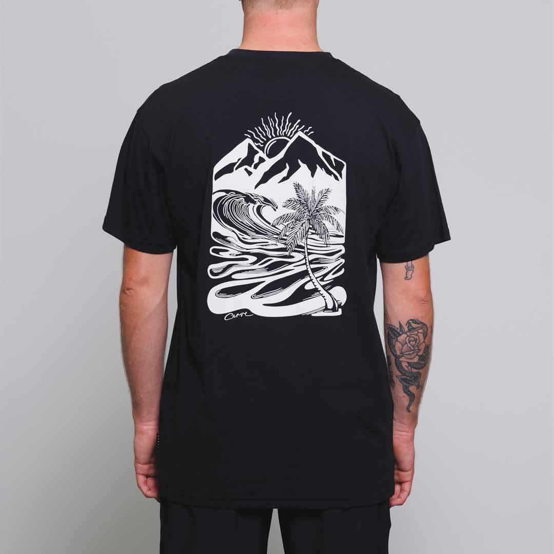 Stewarts Menswear Carve Surfwear Corfu Tee. This is a regular fit men's short sleeve T-shirt with small logo chest print and large back graphic print. With sizes from S to 5XL, no-one is excluded from having up to date seasonal fashion. Image is model wearing black t-shirt showing back print which is a mountains and waves graphic.