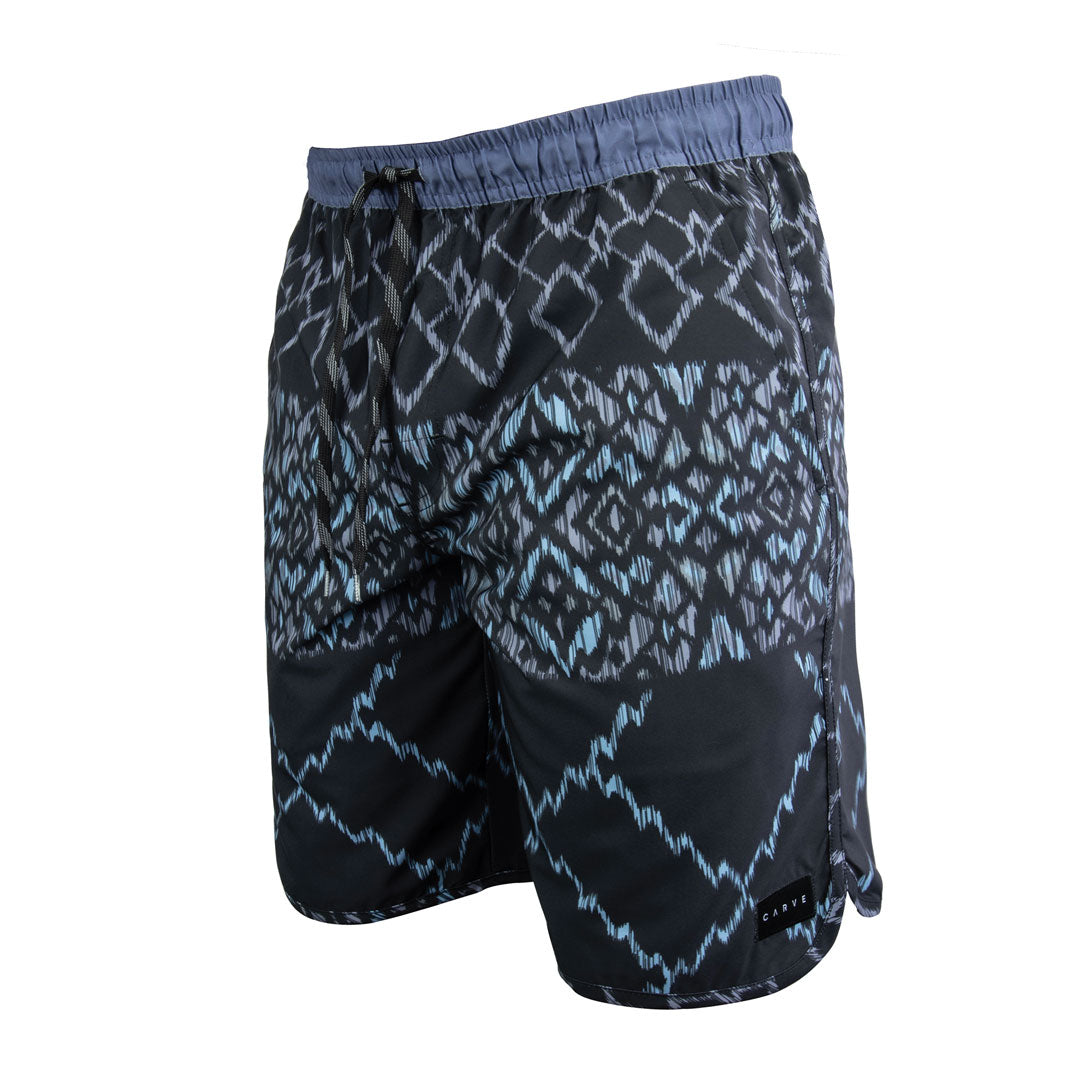 Stewarts Menswear Carve Surfwear Shockwave elastic waist boardie. Designed with a scoop leg with a 19" outer leg length and a contrast coloured elastic waistline with drawcord and mock fly front. Colour is black with a blue sublimation print. Print is geometric of nature with "shockwave" theme.