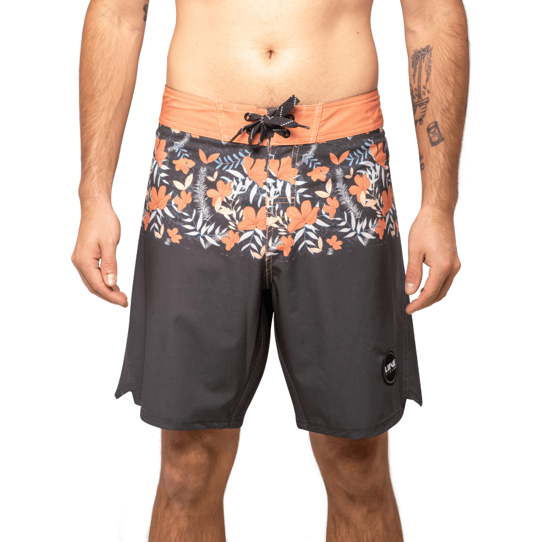 Stewarts Menswear Liive Vision Apparel Duo boardshort. Fitted waist with drawcord, back patch pocket with velcro closure and key loop in the back pocket. Orange waistband with orange/white/charcoal floral print block at top of shorts. Bottom of shirts is solid charcoal colour. Pocket at back is Orange. Front View.