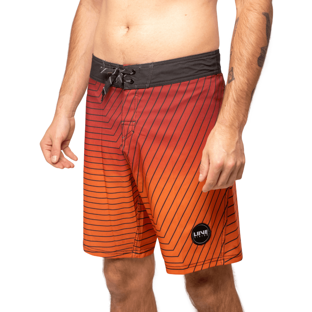 Stewarts Menswear Liive Apparel Cartesian Boardshort. Fitted waist with drawcord, back patch pocket with velcro closure and key loop in the back pocket. Charcoal waistband. Trendy gradient colour design in red/orange shades with charcoal stripe all over. Front View.