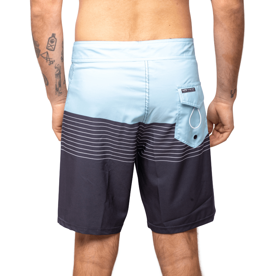 Stewarts Menswear Liive Vision Apparel. Revival Boardshort. light blue colour block and top and navy blue colour block at bottom with light blue stripes through mid-section. Fitted waist with drawcord, back patch pocket with velcro closure and key loop in the back pocket. Back  View.