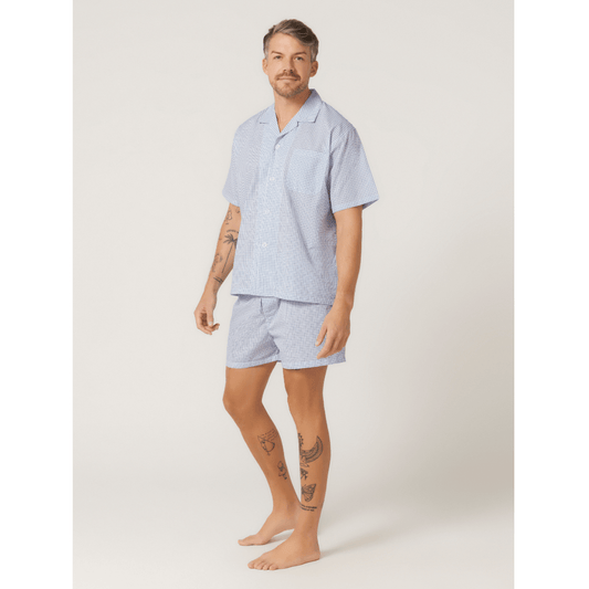 Stewarts Menswear Lynx Short pyjama set. Photo shows model wearing men's short pyjama set. Colour is called "off the grid blue," a white base with blue grid check all over.