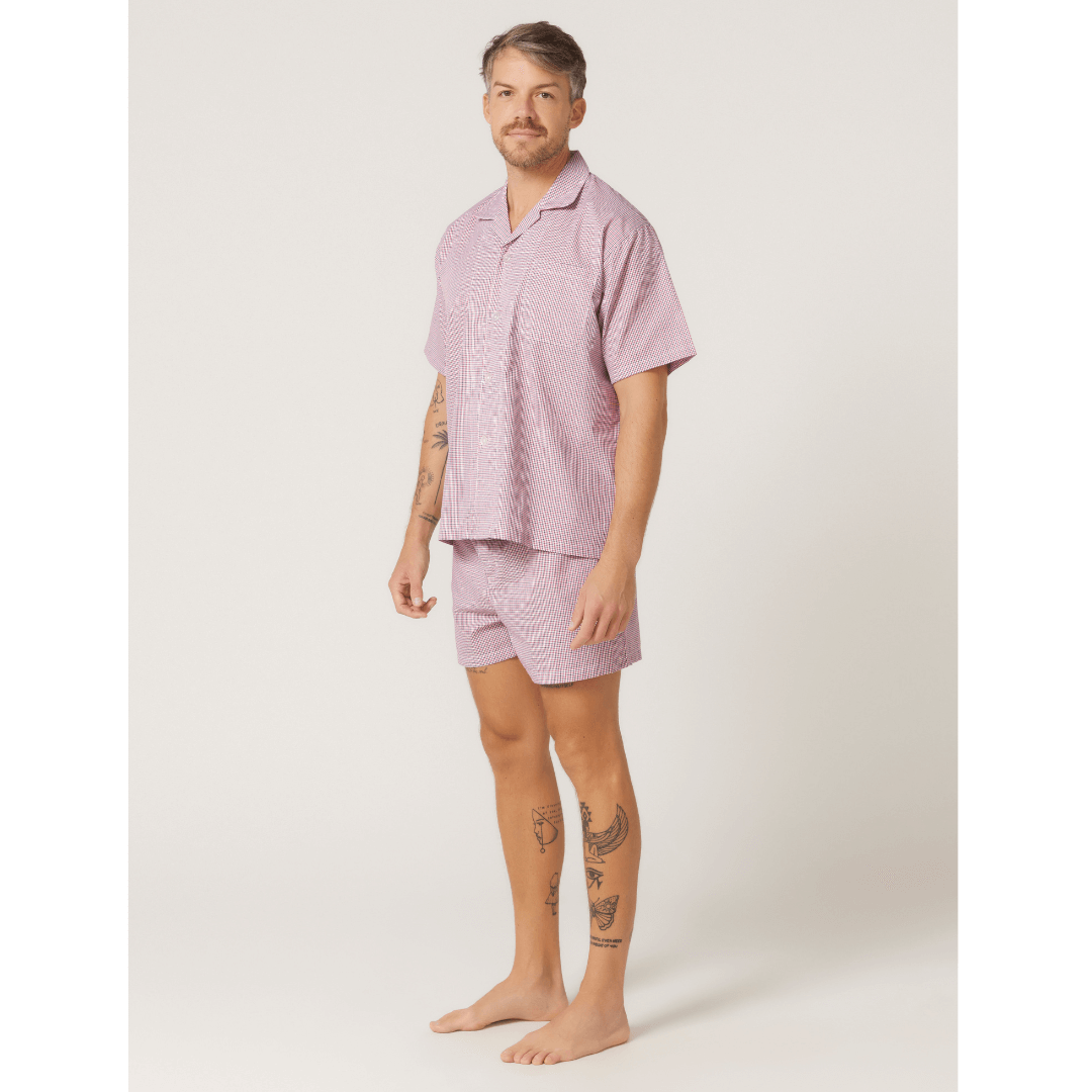 Stewarts Menswear Lynx Short pyjama set. Photo shows model wearing men's short pyjama set. Colour is called "off the grid red," a white base with red grid check all over.