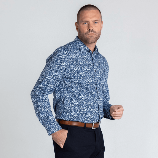 Stewart's Menswear, Mullumbimby. Photo shows model wearing Dale long sleeve shirt from Blackwood Apparel. Front View. Colour is white with tiny floral print all over in shades of Navy and grey.