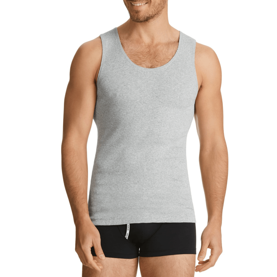 Man wearing a gray chesty bond singlet and black underwear on a white background. Bonds Chesty Bond Singlet available at Stewart’s Menswear Mullumbimby in ribbed cotton with classic men’s styling.