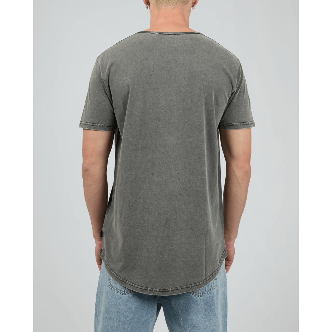 Man wearing Silent Theory Tail Tee available from Stewart's Menswear in Mullumbimby. Pigment washed scooped tail at back, charcoal colour, back view.