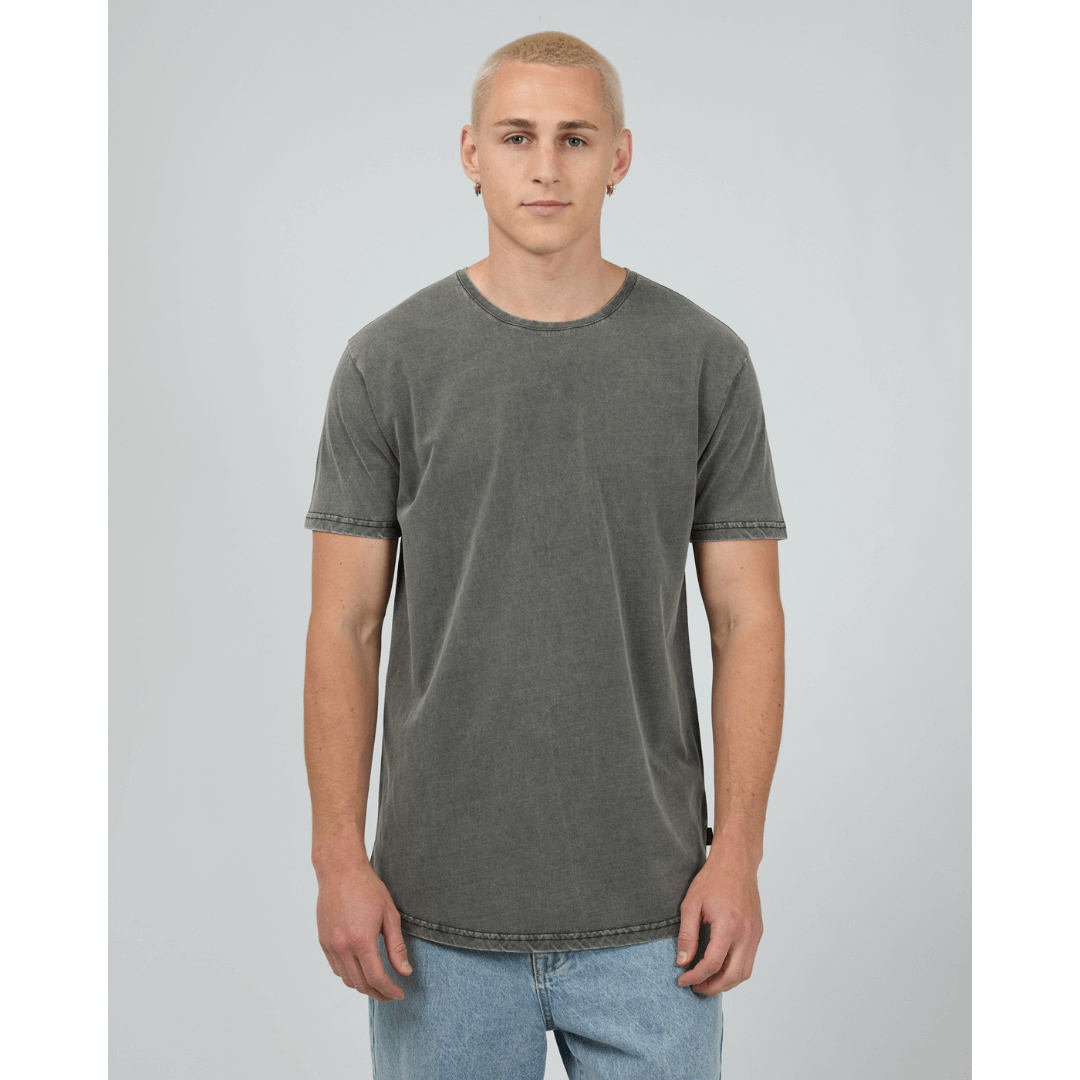 Man wearing Silent Theory Tail Tee available from Stewart's Menswear in Mullumbimby. Pigment washed scooped tail at back, charcoal colour, front view.