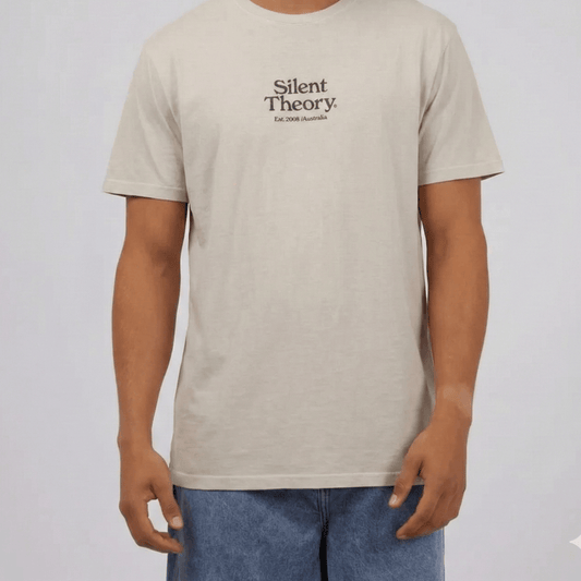 Model wearing Silent Theory Classic Embroidered tee available from Stewart's Menswear Mullumbimby. Light grey tee with embroidered Silent Theory logo on front chest.
