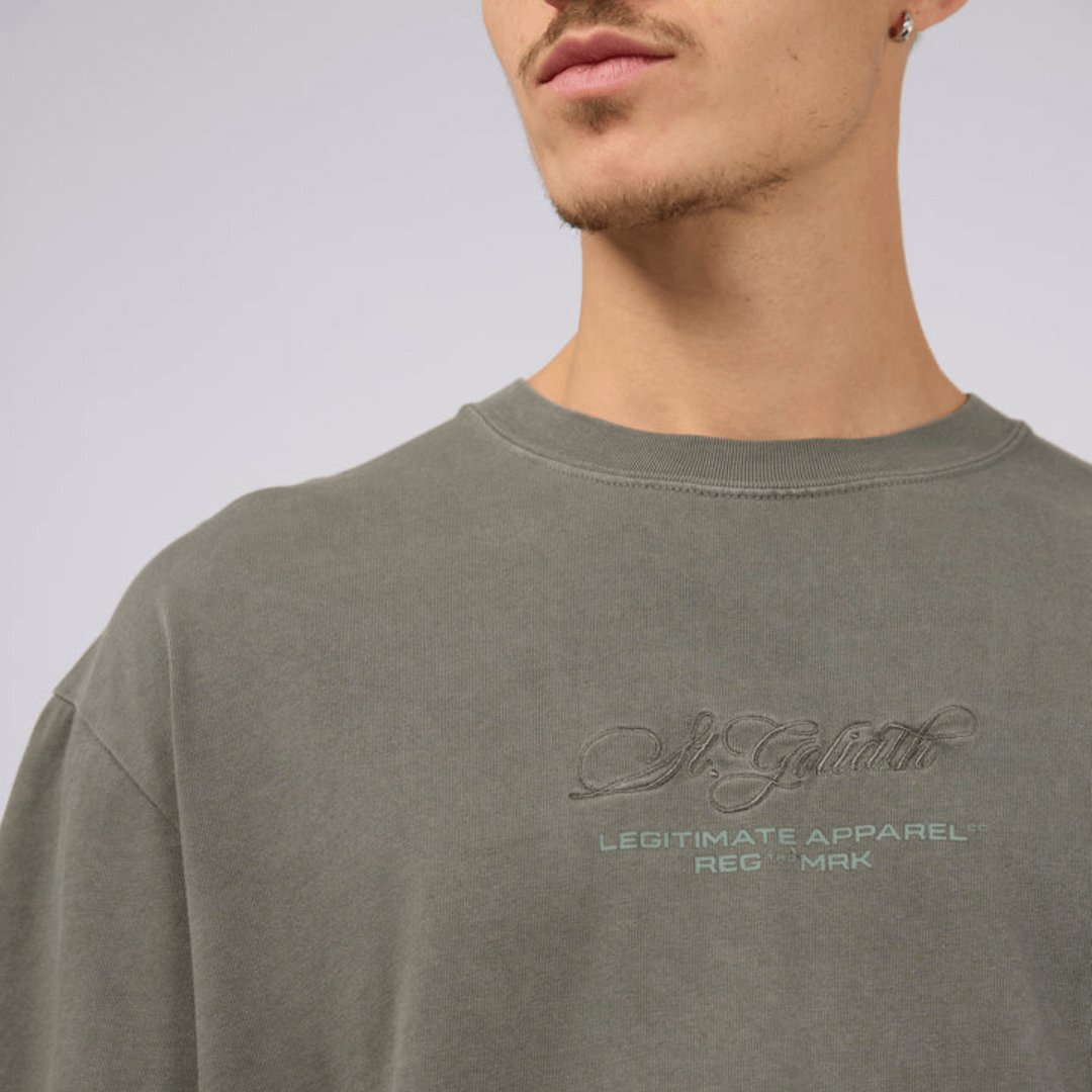 Close of up embroidery on front of St Goliath Arching tee available from Stewarts Menswear, Mullumbimby.