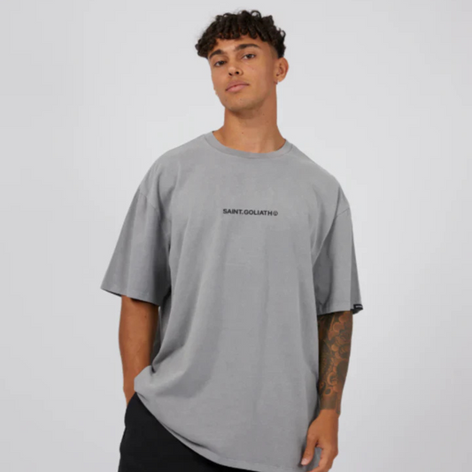 Stewart's Menswear, Mullumbimby. PHoto shows model wearing St Goliath ID tee. Heavyweight oversize tee, light grey colour with small saint goliath print across chest.
