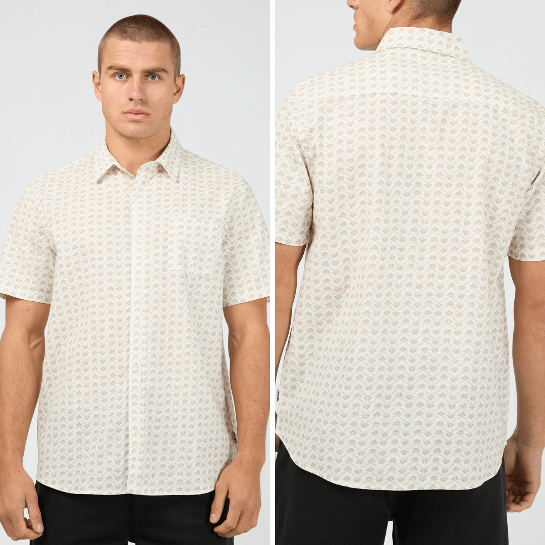 Front and Back Views of model wearing St Goliath Lotus Short Sleeve Shirt available at Stewart’s Menswear Mullumbimby. Men’s relaxed-fit cotton short sleeve shirt with collared neckline and button-down design. White shirt with small tan coloured lotus print all over.