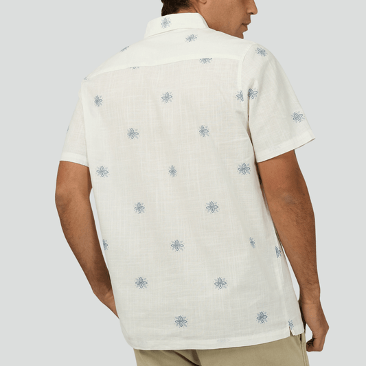 Back view of a person wearing St Goliath Medusa shirt, a white short-sleeve shirt with blue floral patterns on a plain white background. Available at Stewarts Menswear, Mullumbimby.