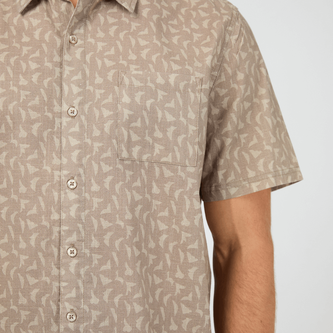 Close up view of model wearing St Goliath Portsea Short Sleeve Shirt available at Stewart’s Menswear Mullumbimby. Men’s relaxed-fit cotton shirt with button-down front. Save $20. Mushroom colour with small cream coloured geometric print all over.