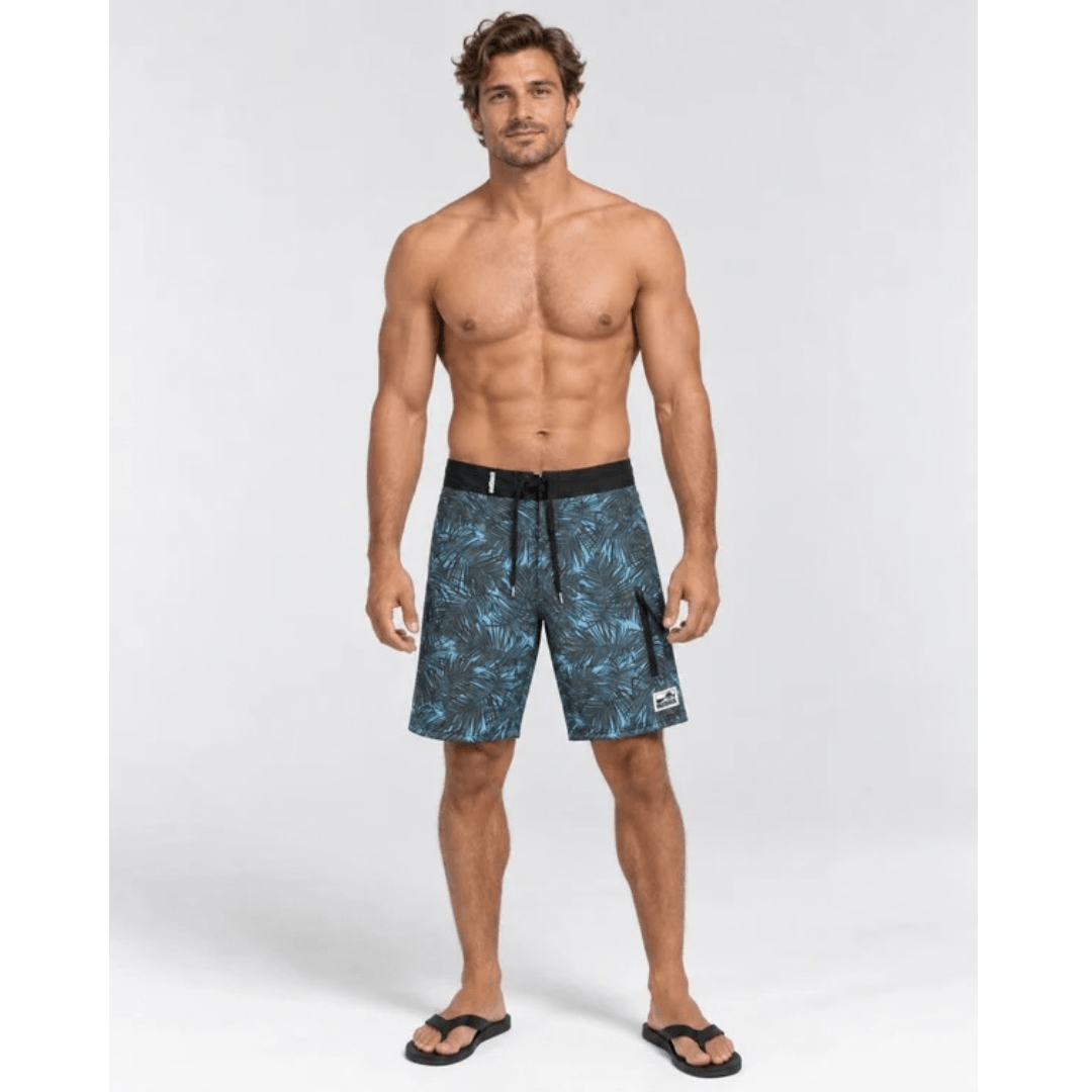 Model wearing Outback Supply Co black with blue  leaf print boardshorts with high waist and back pocket, available at Stewart's Menswear Mullumbimby.