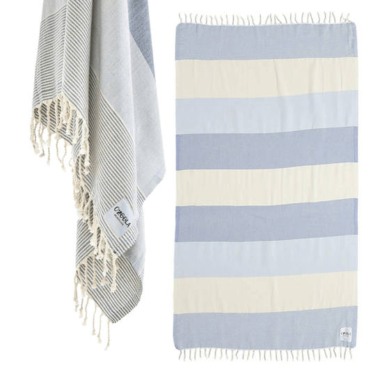 Stewarts Menswear Ozoola Johnny Towel. The Johnny Towel is made from 100% Turkish Cotton which is super absorbent and fast drying.  Sized at 180 x 100cm with knotted fringing at each end. Ideal for endless beach days, and lazy pool days.  Soft and light, it is perfect for travelling and it can also be used as a sarong.  Colour is Natural Blue with wide stripes of constrast colours.