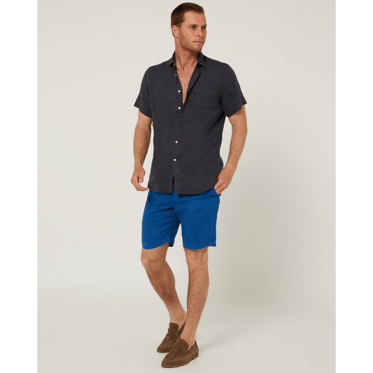 Model wearing men's Pilbara Collection by Ritemate Workwear Modern Fit Linen Shorts in deep blue with tone on tone Windmill embroidery paired with classic fit men's linen shirt, available at Stewart's Menswear Mullumbimby.