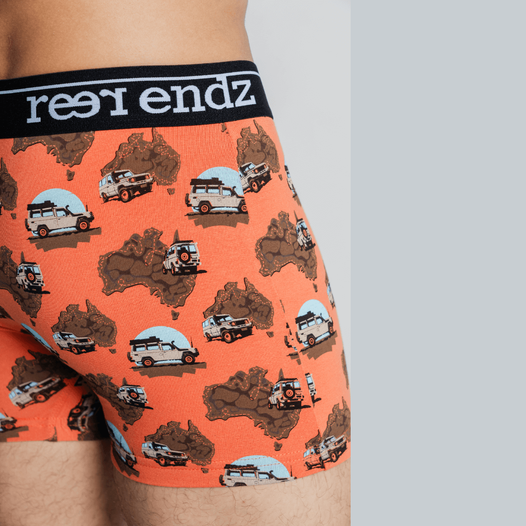 Stewarts Menswear Reer Endz Organic cotton underwear. Cruisin is an orange coloured men's trunk with maps of australia and a "troopy" car printed all over. Photo is a close up of model wearing Cruising underwear.