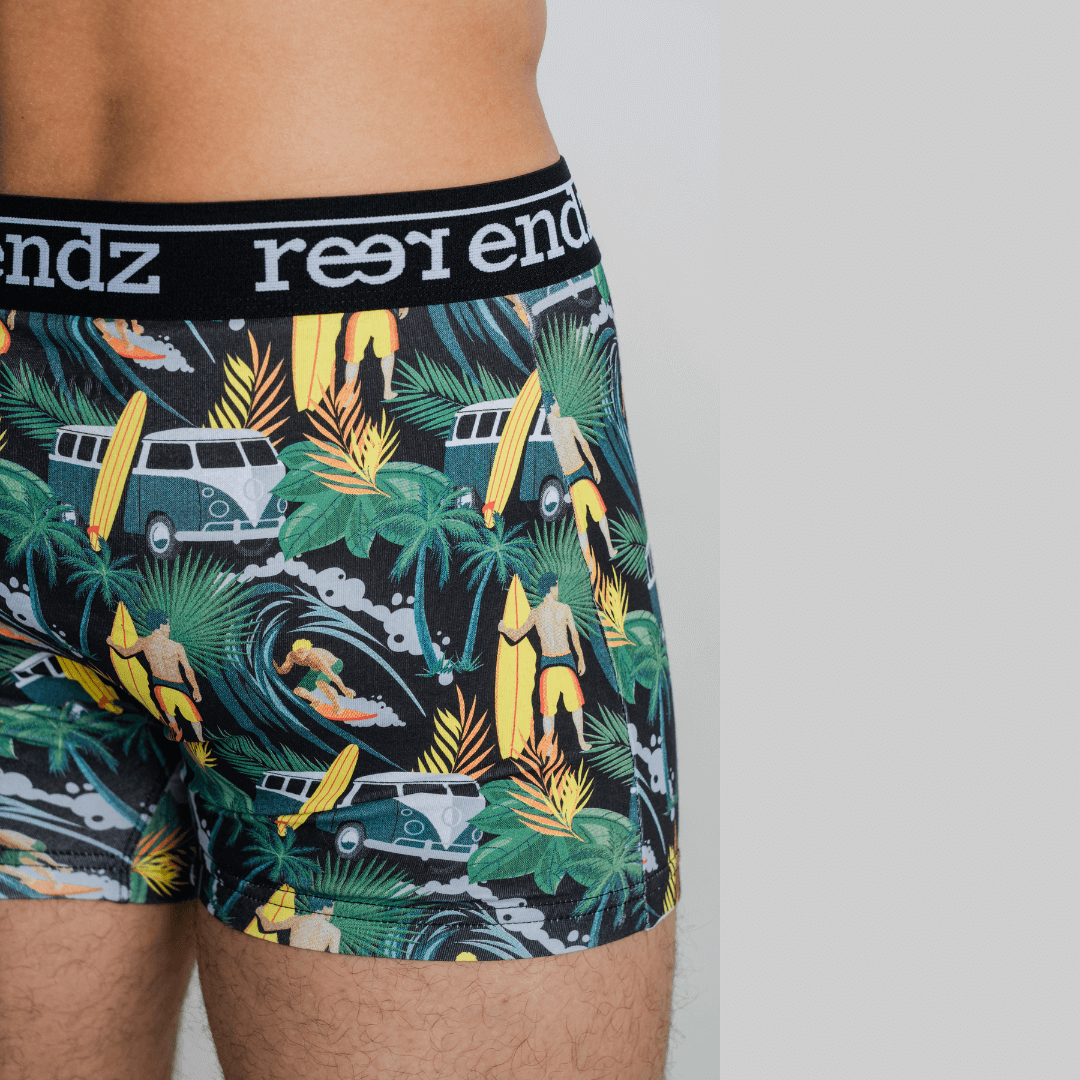 Stewarts Menswear Reer Endz organic cotton underwear. Offshore Vibes is a leafy green background trunk with  combis, surfers and surfboards printed all over. Photo shows close up of model wearing Offshore Vibes Reer Endz Underwear.