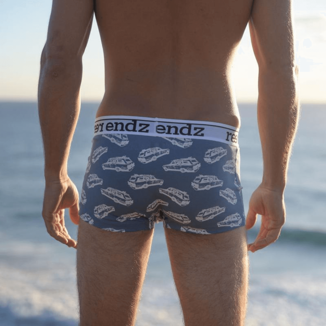 Stewarts Menswear Reer Endz Underwear. Made from Organic Cotton. Photo shows model wearing Chasing Waves print trunks. Light blue trunks with station wagon car print. Back View.