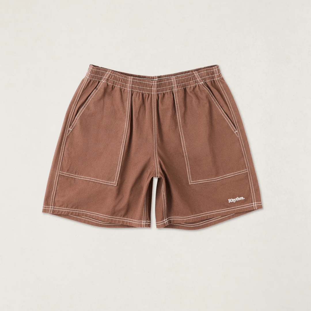 Flat-lay of Rhythm Contrast Stitch Jam shorts in chocolate brown with white contrast stitching.