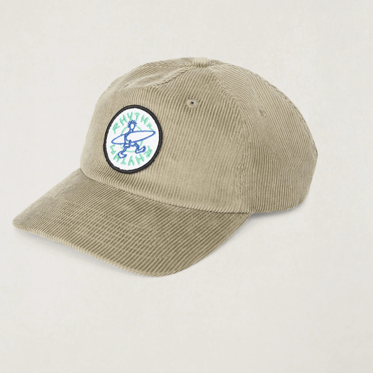 A stone coloured corduroy baseball cap with a circular embroidered patch on the front featuring a blue and green surfer graphic. Rhythm Jaunt Cord cap available from Stewart's Menswear in Mullumbimby