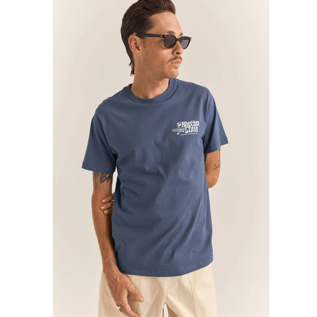 Stewarts Menswear Rhythm Livin. Rhythm Livin T-shirt. Colour is Navy. Small left chest print shows surfer carrying a surfboard with the words "Rhythm Livin." No print on back.