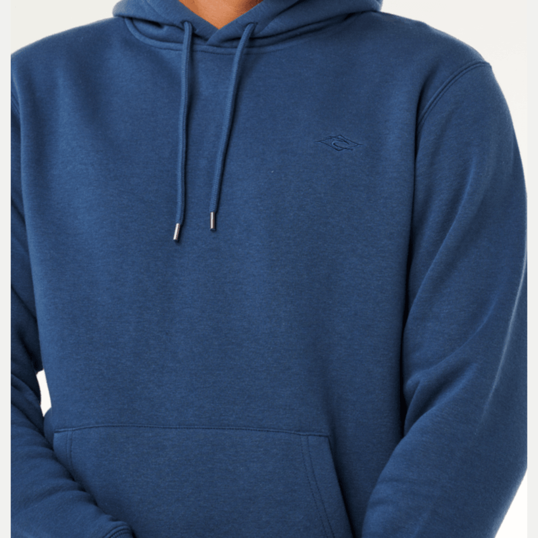 Man wearing a blue hoodie on a white background. Close up view of Rip Curl Classic Surf Hoodie in light navy available from Stewart's Menswear, Mullumbimby.