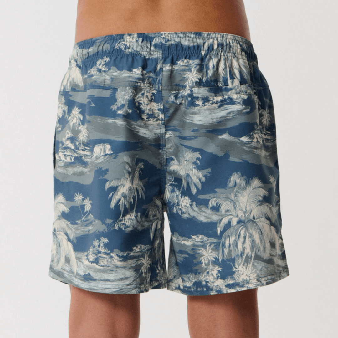 Stewarts Menswear Rip Curl Dreamers Volley Short. Colour is pine, a blue base with pine green island/palm tree print all over. Photo shows back view of model wearing Rip Curl Dreamers Volley Short available at Stewarts Menswear, Mullumbimby