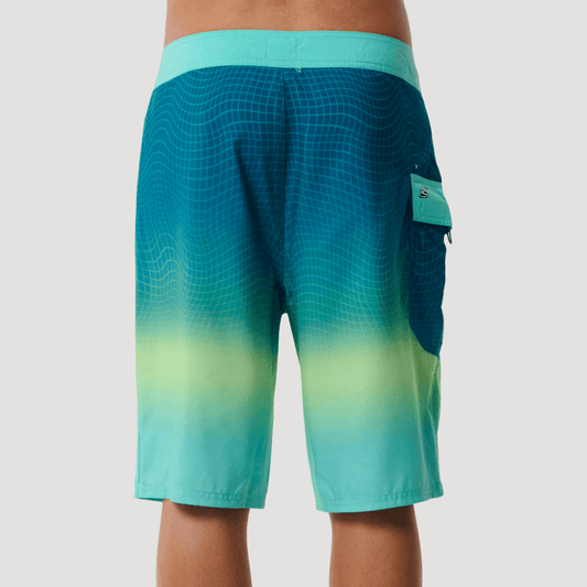 Back View of model wearing Rip Curl Shock Wave Boardshort Blue/Green available at Stewart’s Menswear Mullumbimby. Men’s quick-dry DWR surf shorts with side pocket.