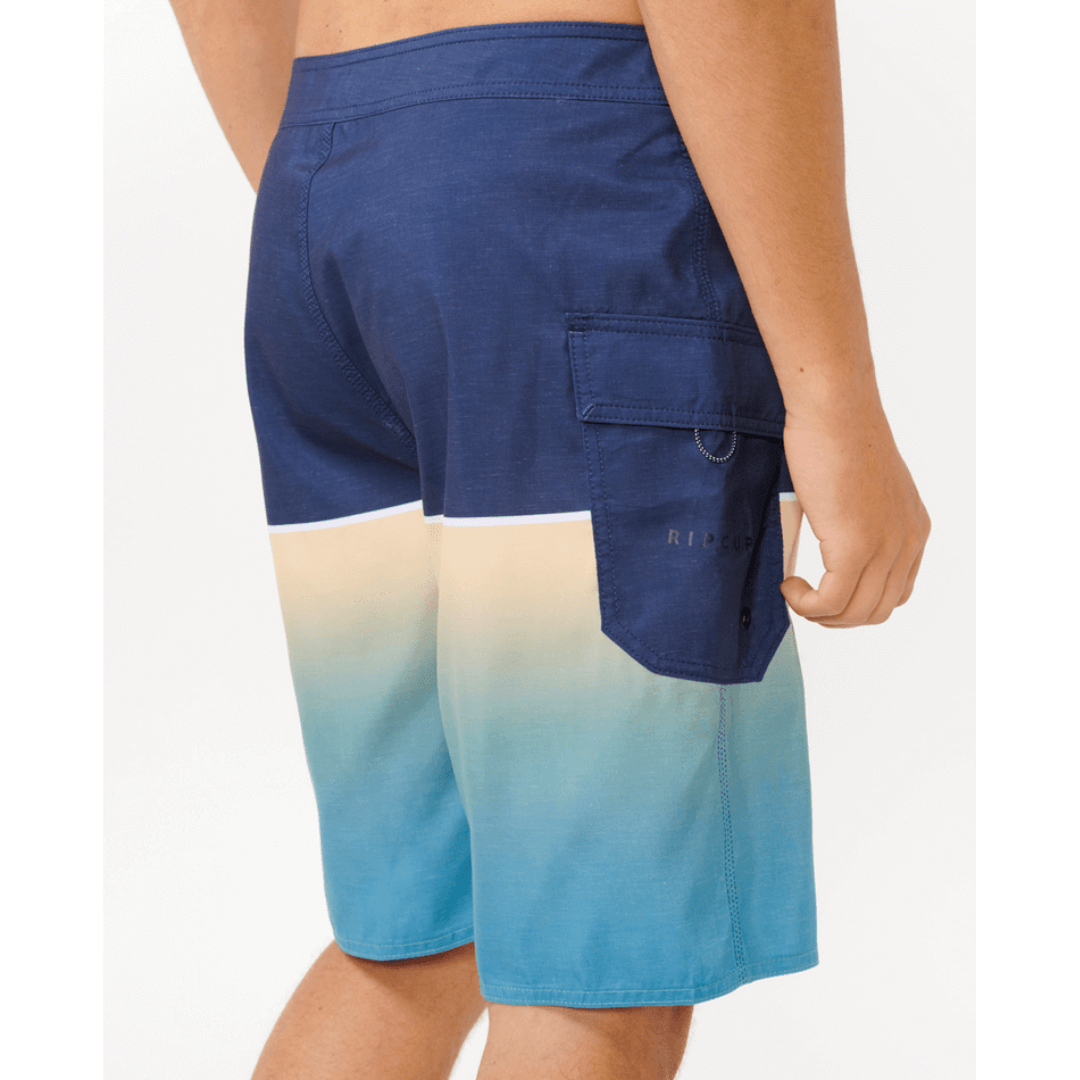 Stewart's Menswear Rip Curl Dawn Patrol Boardshorts. Navy top half with gradient blue bottom half. Photo shows close up side/back view of model wearing Rip Curl Dawn Patrol boardshorts. Colour is called Ocean.