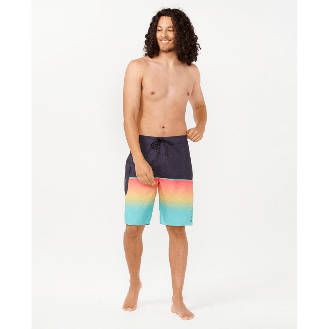 Stewart's Menswear Rip Curl Dawn Patrol Boardshorts. Black top half with gradient red/blue bottom half. Photo shows front view of model wearing Rip Curl Dawn Patrol boardshorts. Colour is called Washed Red.