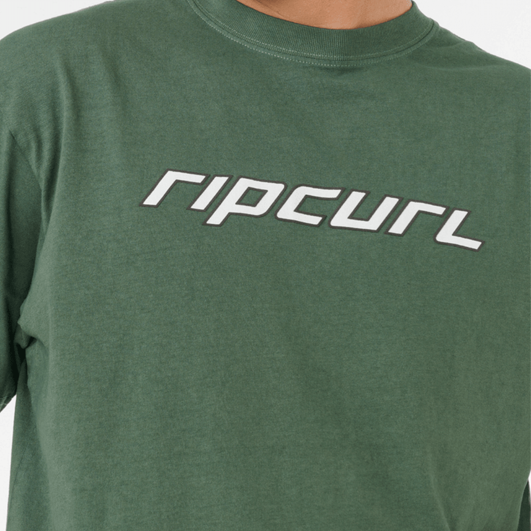 Rip Curl Nu Dosed Tee available at Stewart’s Menswear Mullumbimby. Men’s loose fit cotton tee with puff print Rip Curl logo. Colour is mountain green. Photo shows close up view of Logo.
