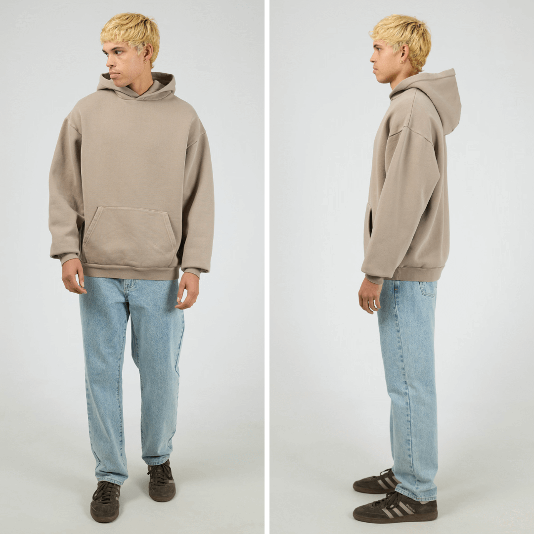 Model wearing cement coloured Silent Theory Box Hoodie with hood and kangaroo pocket, available at Stewart’s Menswear Mullumbimby.