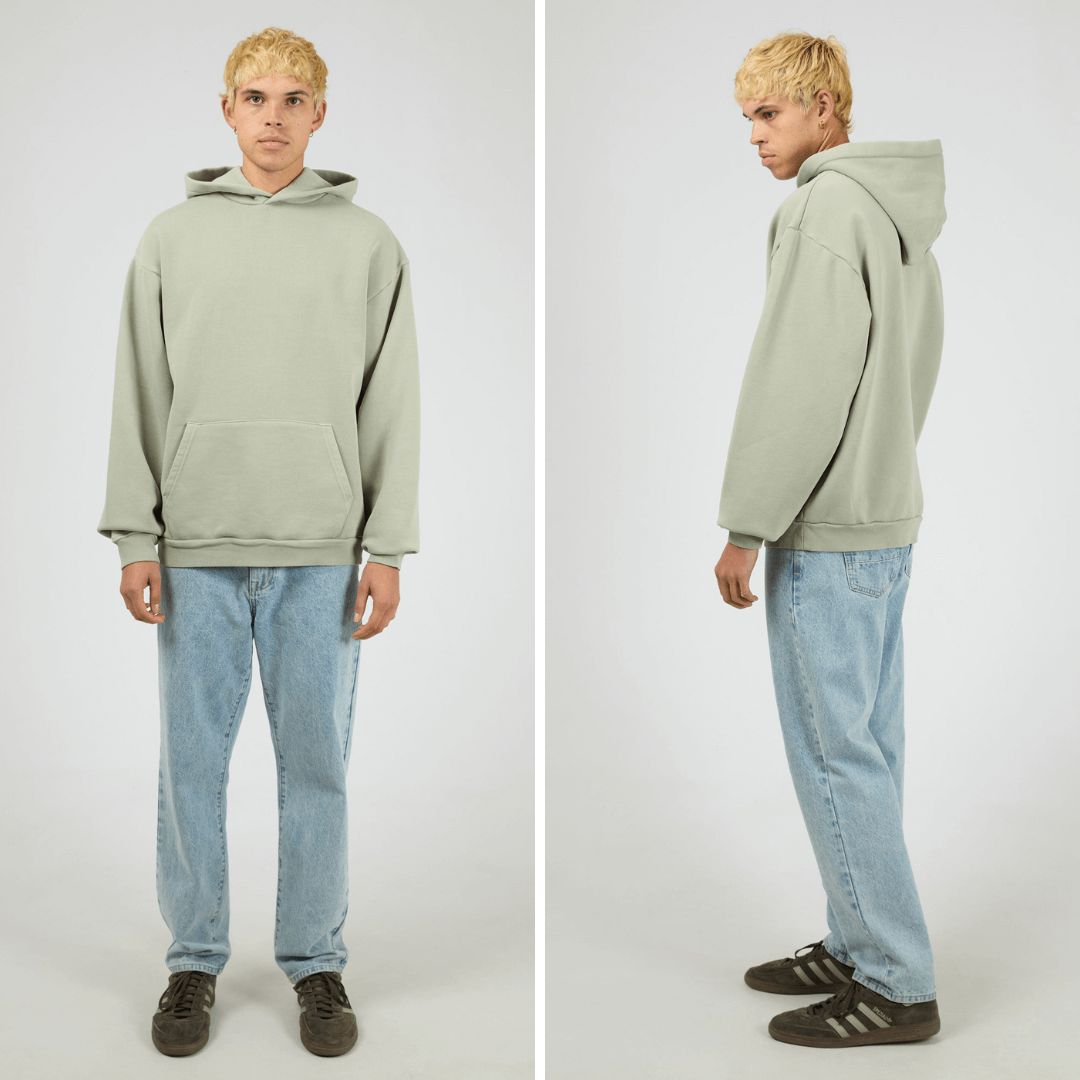 Model wearing sage coloured Silent Theory Box Hoodie with hood and kangaroo pocket, available at Stewart’s Menswear Mullumbimby.