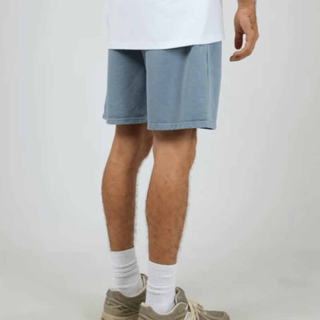 Back View of model wearing Silent Theory Essential Theory Short V2 available at Stewart’s Menswear Mullumbimby. Men’s unbrushed French terry cotton shorts with elastic waist and pockets. Light Blue