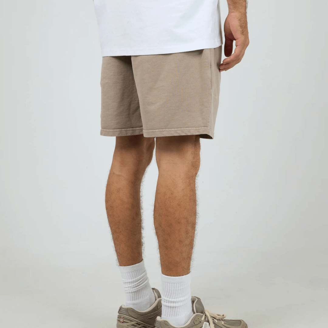 Back View of model wearing Silent Theory Essential Theory Short V2 available at Stewart’s Menswear Mullumbimby. Men’s unbrushed French terry cotton shorts with elastic waist and pockets. Mushroom colour
