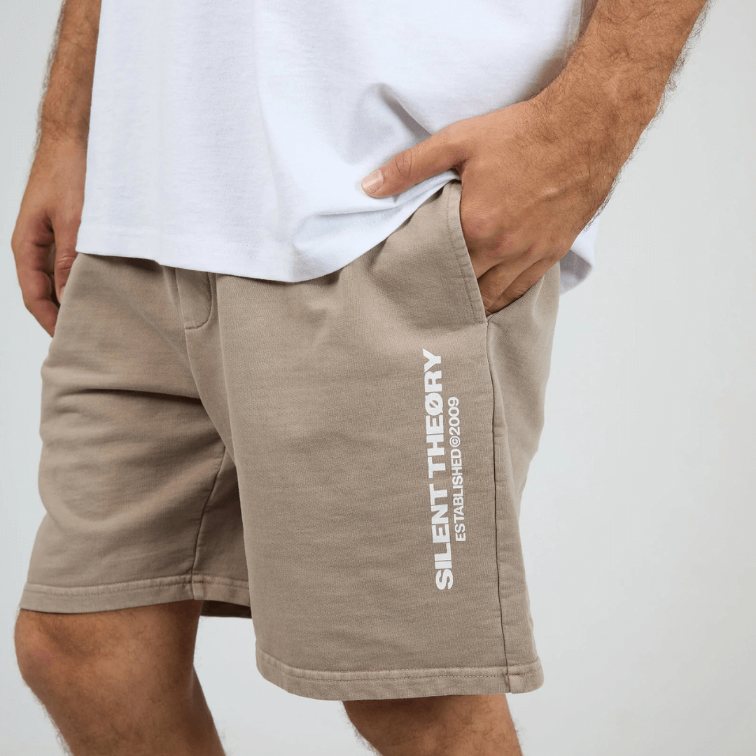 Front View of model wearing Silent Theory Essential Theory Short V2 available at Stewart’s Menswear Mullumbimby. Men’s unbrushed French terry cotton shorts with elastic waist and pockets. Mushroom Colour.
