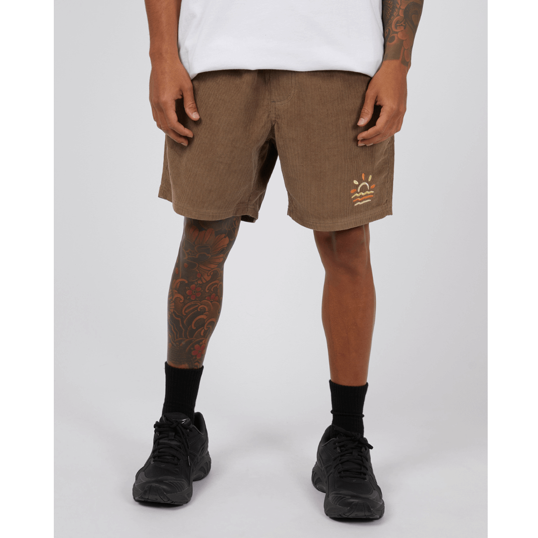 Stewarts Menswear St Goliath Wind Down Cord Short. Photo shows front view of model wearing St Goliath Wind Down Cord short. Colour is brown with a yellow and orange sun/ocean logo embroidered on front.