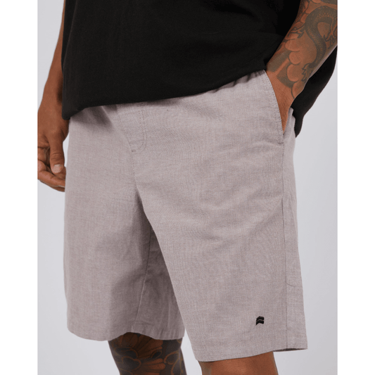 Stewarts Menswear St Goliath Dune Short.  A light coloured knee-length elastic waist short with a very fine brown stripe running through. Photo shows close up of model wearing St Goliath Dune Short.