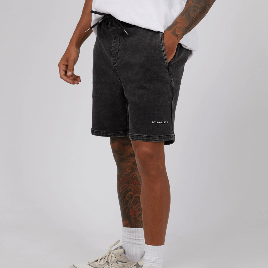 Stewart's Menswear, Mullumbimby. Model wearing St Goliath Fairhaven short in washed black. St. Goliath logo on leg.