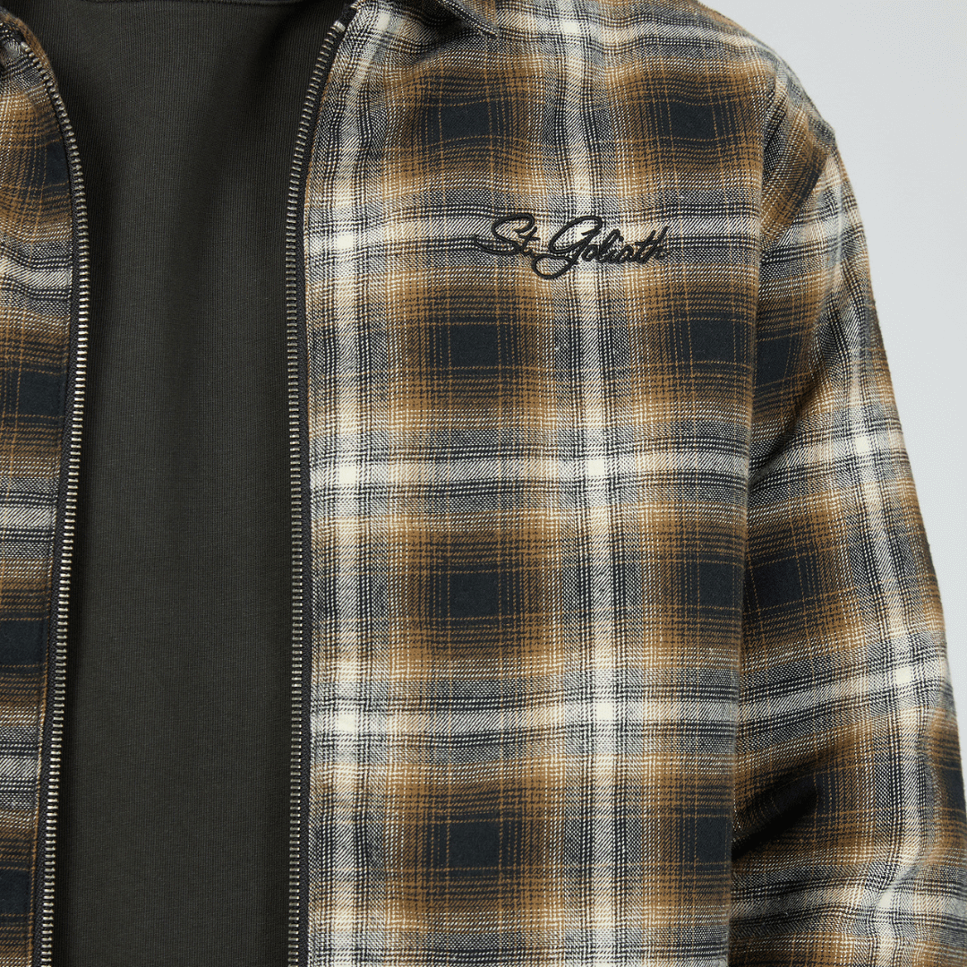 Close up photo of front of St Goliath Floyd Shacket available at Stewart’s Menswear Mullumbimby. 100% cotton brushed check (navy, brown, white) shacket with quilted lining and zip-up front.