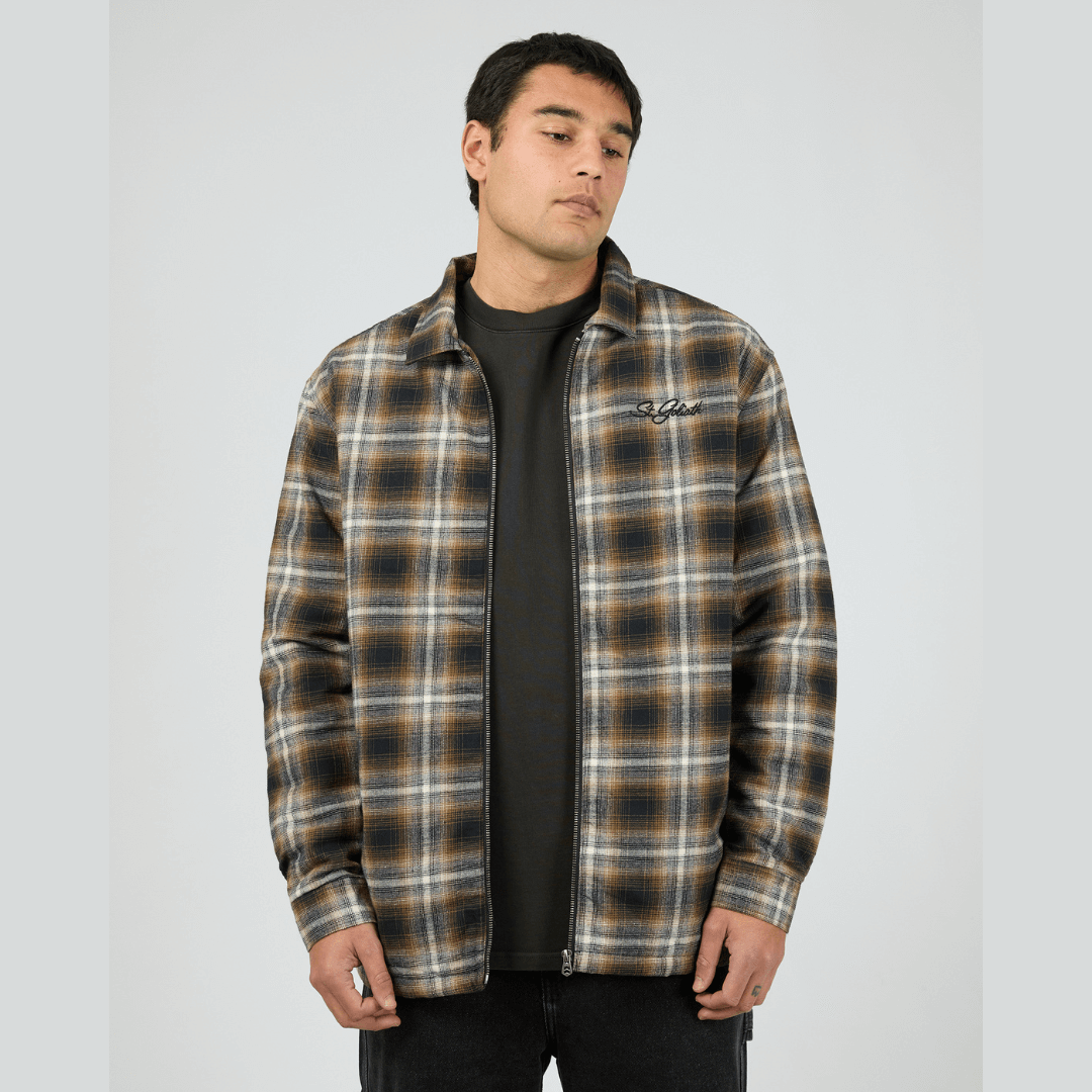 Model wearing St Goliath Floyd Shacket available at Stewart’s Menswear Mullumbimby. 100% cotton brushed check (navy, brown, white) shacket with quilted lining and zip-up front.