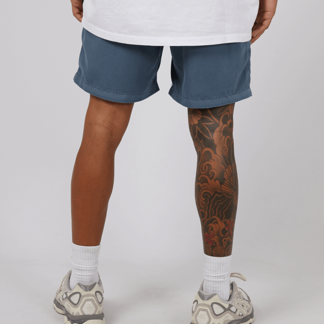 Stewarts Menswear St Goliath Illusion short. Made from 100% recycled material, Its faded look adds a touch of trendiness while the quick dry micro fibre material ensures comfort. Colour is Mid Blue. Image shows back view of model wearing St Goliath Illusion shorts.