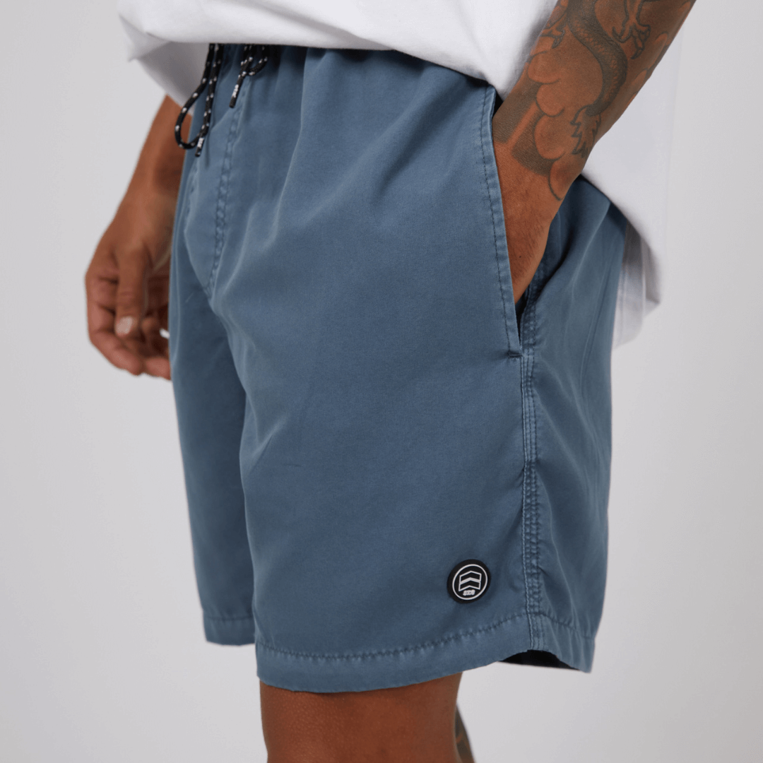 Stewarts Menswear St Goliath Illusion short. Made from 100% recycled material, Its faded look adds a touch of trendiness while the quick dry micro fibre material ensures comfort. Colour is Mid Blue. Image shows close up of model wearing St Goliath Illusion shorts.