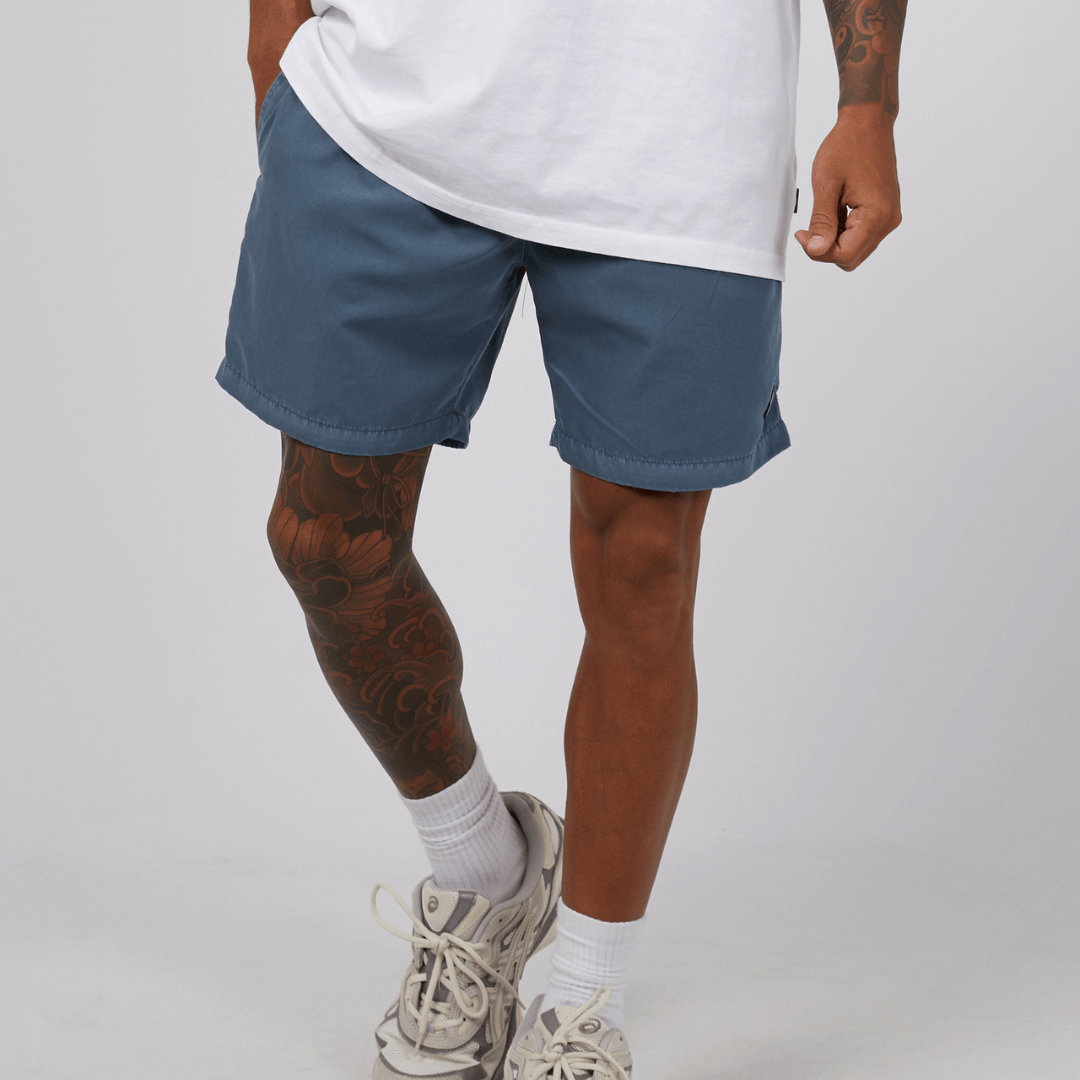 Stewarts Menswear St Goliath Illusion short. Made from 100% recycled material, Its faded look adds a touch of trendiness while the quick dry micro fibre material ensures comfort. Colour is Mid Blue. Image shows front view of model wearing St Goliath Illusion shorts.