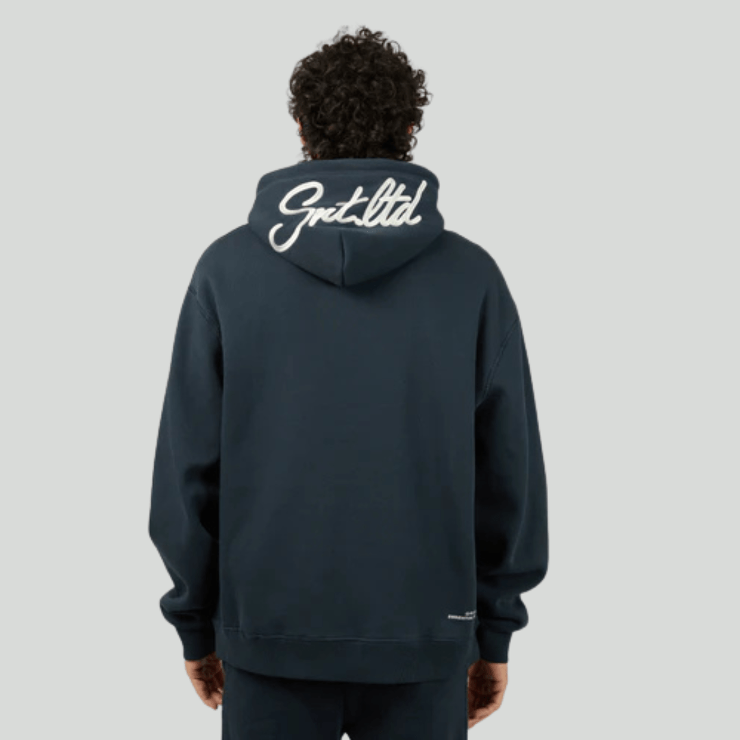 Back view of person wearing a navy hoodie with St Golilath branding on the back against a light grey background. St Goliath Radio Hoodie available from Stewarts Menswear, Mullumbimby