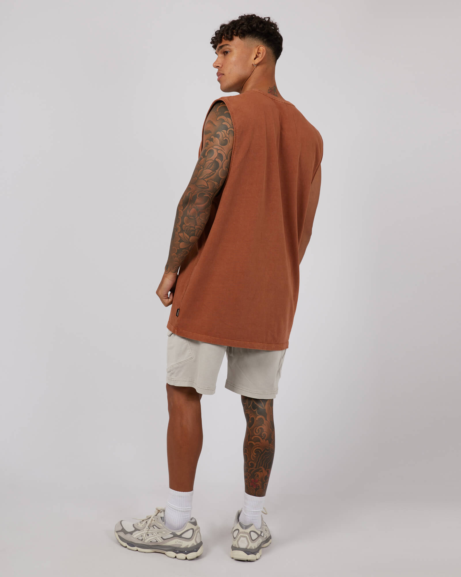 Stewarts Menswear St Goliath Silhouette Muscle Tee. Colour is Mocha. Black flocked branding on front. Photo shows model wearing St Goliath Silhouette Muscle Tee, back view.